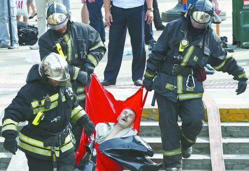 莫斯科15 日早高峰时段发生地铁列车脱轨事故，导致至少20 人死亡。图为救援人员将伤者从地铁站抬出。