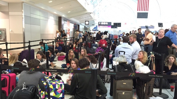 Travellers wait in line at Toronto's Pearson International Airport amid a worldwide grounding of Delta Air Lines departures on Monday morning. 