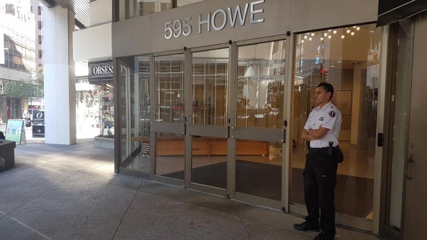 A security guard is posted outside the entrance to PacNet's downtown Vancouver office. The company declined to comment.