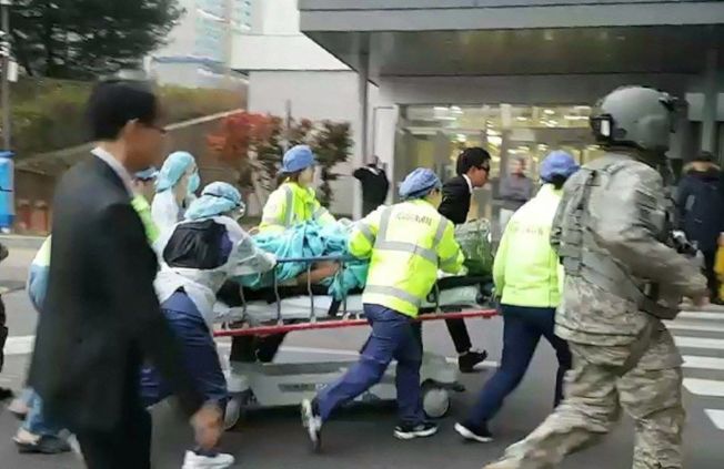 韩国医护人员13日将越境投诚时中枪的北韩军人送往水原市医院急救。（欧新社）