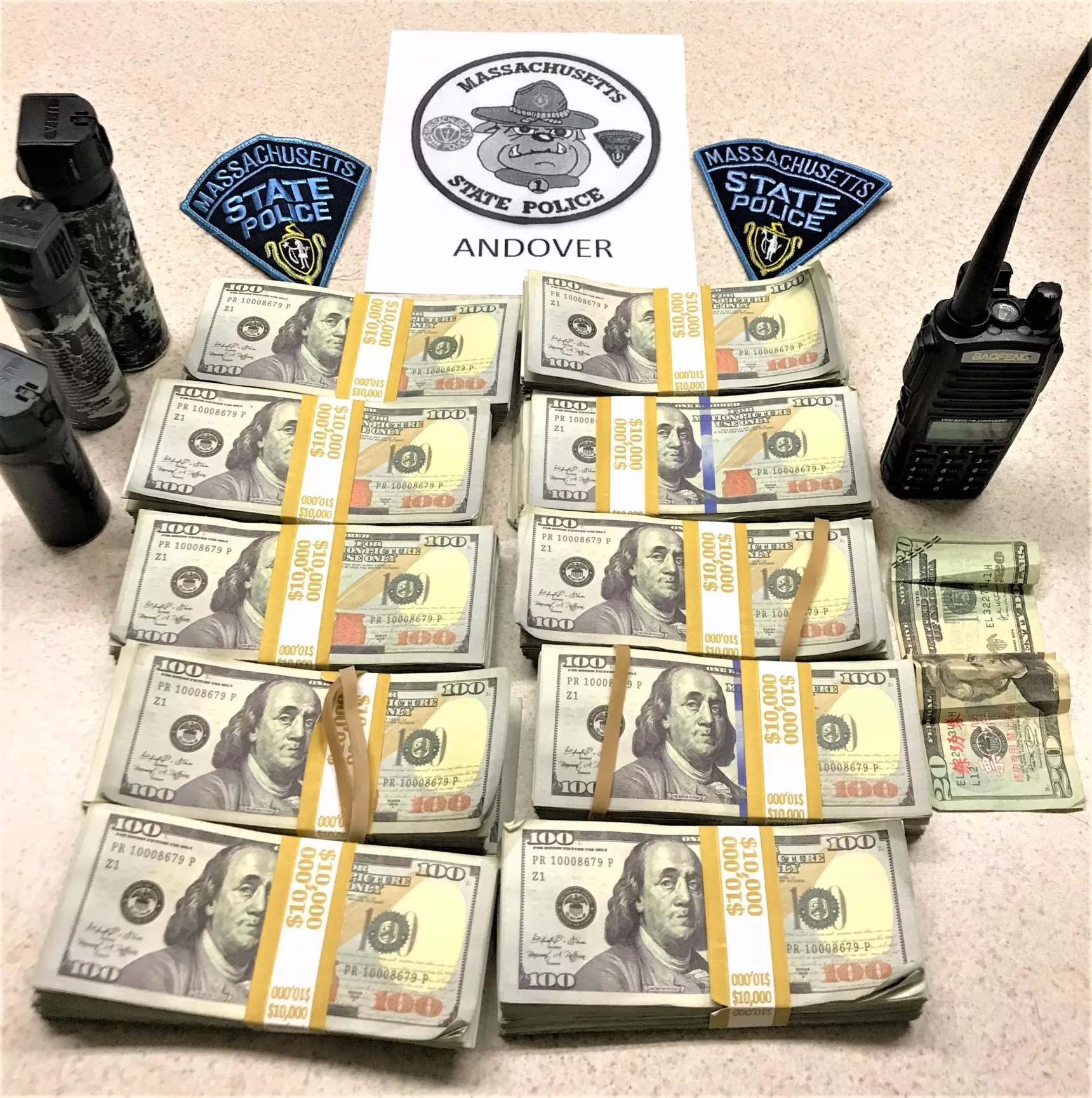 麻州州警拦下一辆闪着警灯的假警车，车内截获数捆假币、三瓶胡椒喷雾，以及一个警用手持式对讲机。(取自麻州州警官方推特)