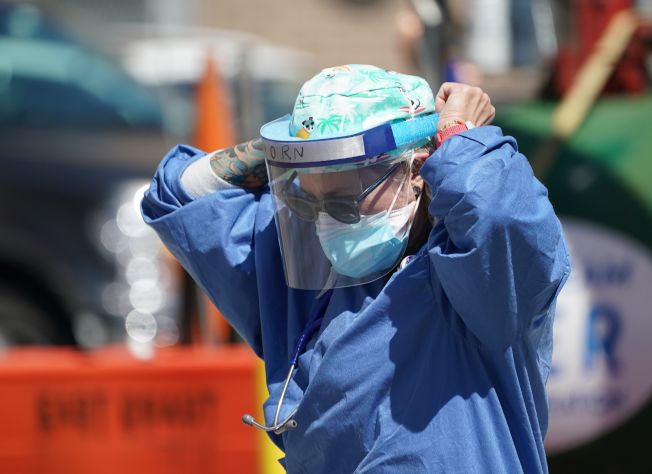 纽约布鲁克林，一位护士走出医院，整理防护服。(Getty Images)