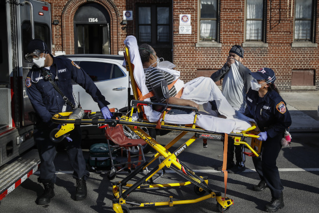 纽约市布朗士一家疗养院爆发群聚感染，图为救护人员将感染的老人送往医院。(美联社)