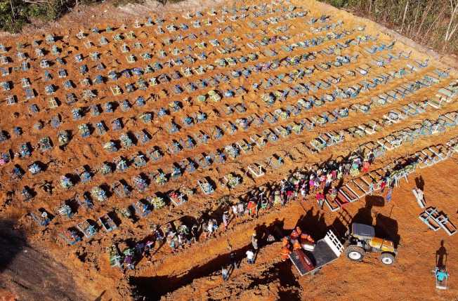 巴西亚玛瑙斯一个公墓的工人日前将棺木从货车上卸下，準备埋入万人冢。（Getty Images）