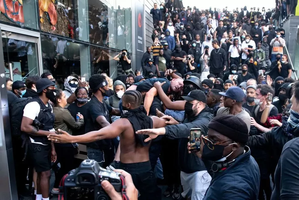 暖心! 一群黑人抗议者将一名受伤白人托举运给警察: 他有生命危险 救救他!