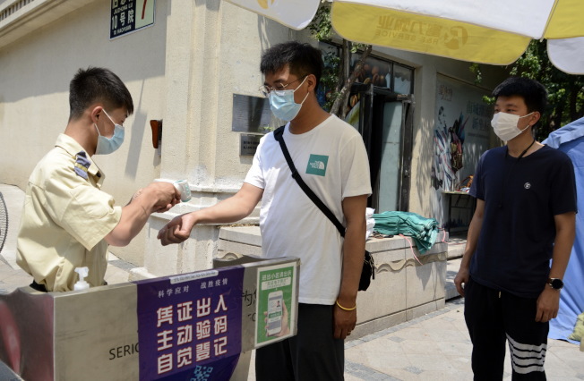 北京大兴区一小区在对民众检测体温。(新华社)