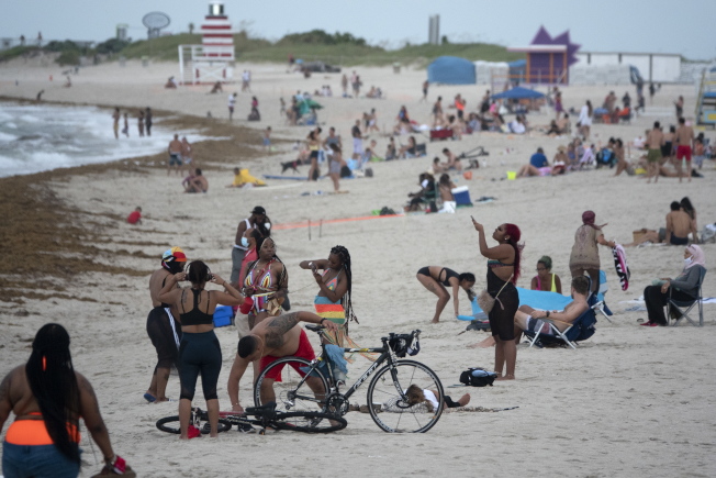 佛州迈阿密海滩，涌进不少泳客。佛州州长德桑提斯18日表示，年轻人染疫的情况明显不断上升。(欧新社)