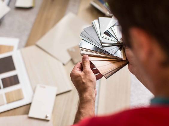 Man seen from behind going through flooring samples