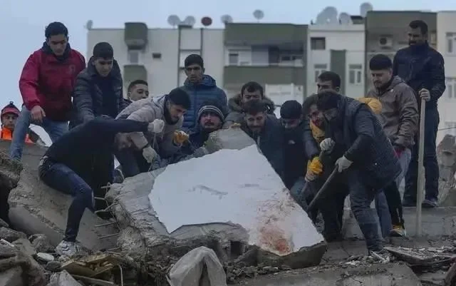 2月6日，土耳其阿达纳，人们在废墟中搜救。图源：视觉中国