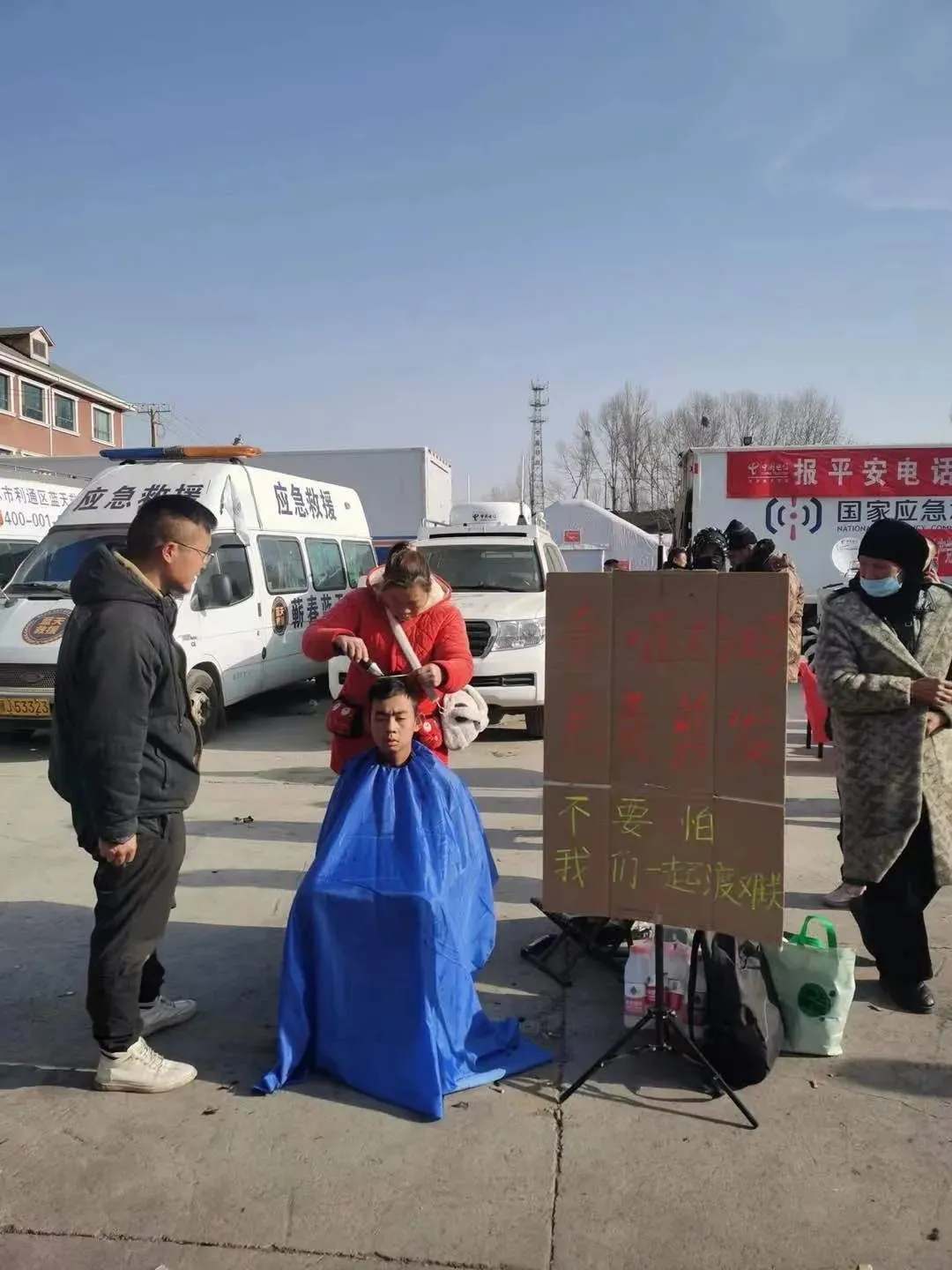 河南小伙刘荣胜原本自驾带聋哑母亲旅行，看到积石山发生地震的消息后志愿前来支援。在安置点，刘荣胜的母亲为受灾民众免费理发。中青报·中青网记者 尹海月/摄